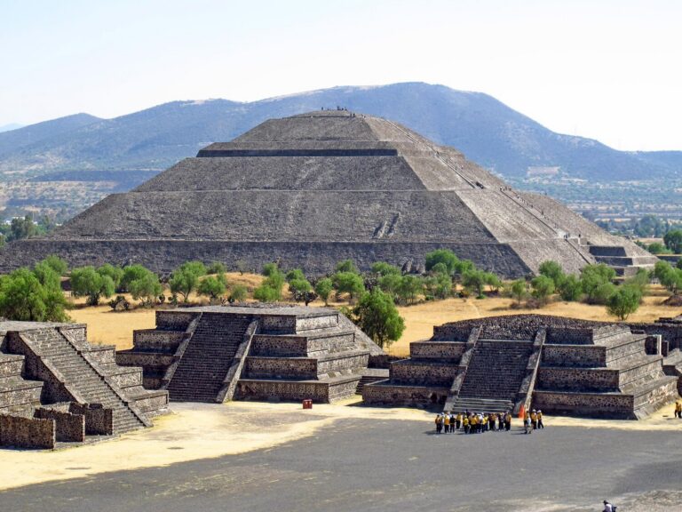 Pyramid of the Sun at Teotihuacan rising behind stepped platforms under a clear sky